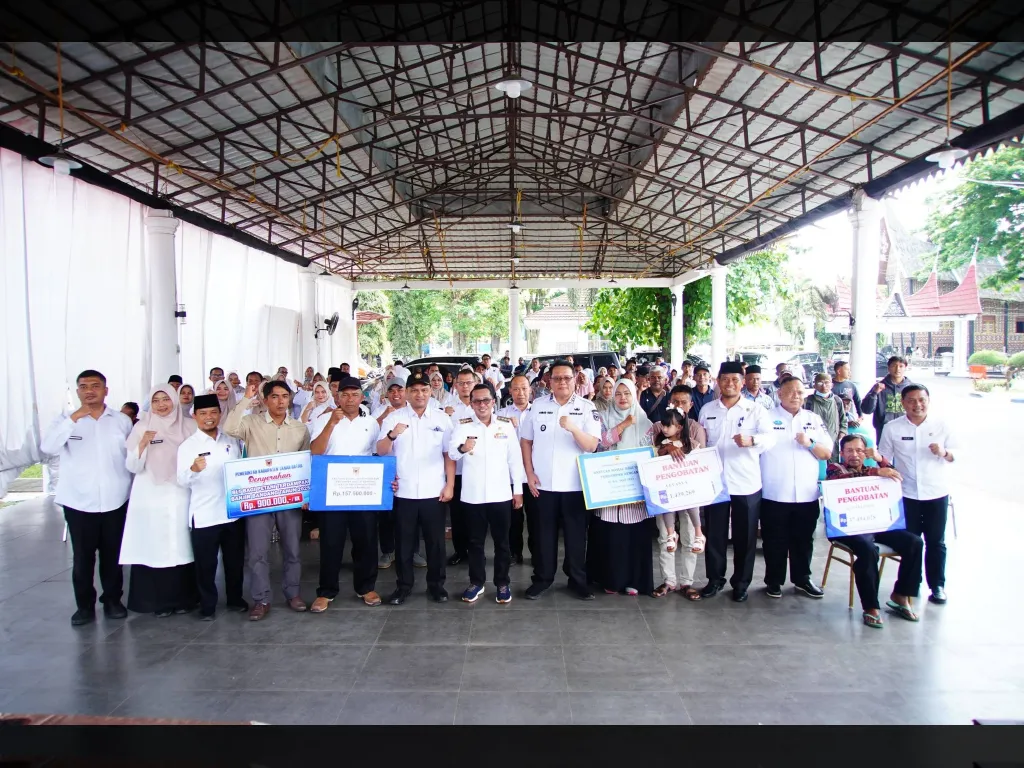 Selepas serahkan bantuan, bupati dan wabup Tanah Datar foto bersama dengan penerima manfaat