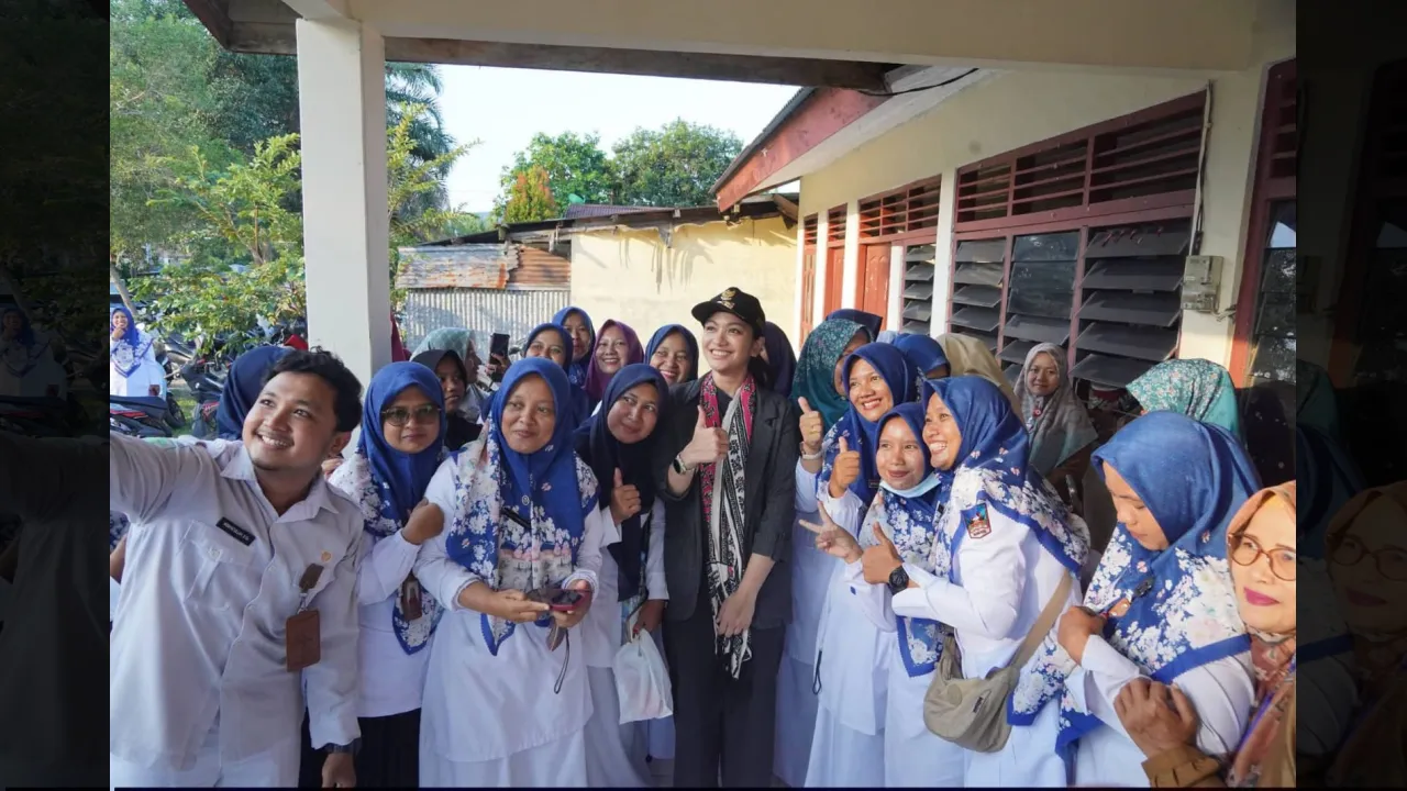 Disela pemberian paket makanan pada ibu hamil dan menyusui, bupati Annisa foto bersama dengan tenaga Posyandu
