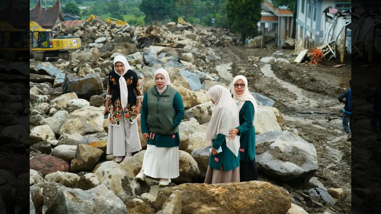 Ketua TPPKK Tanah Datar berada diantara bebatuan sisa galodo Arosuka